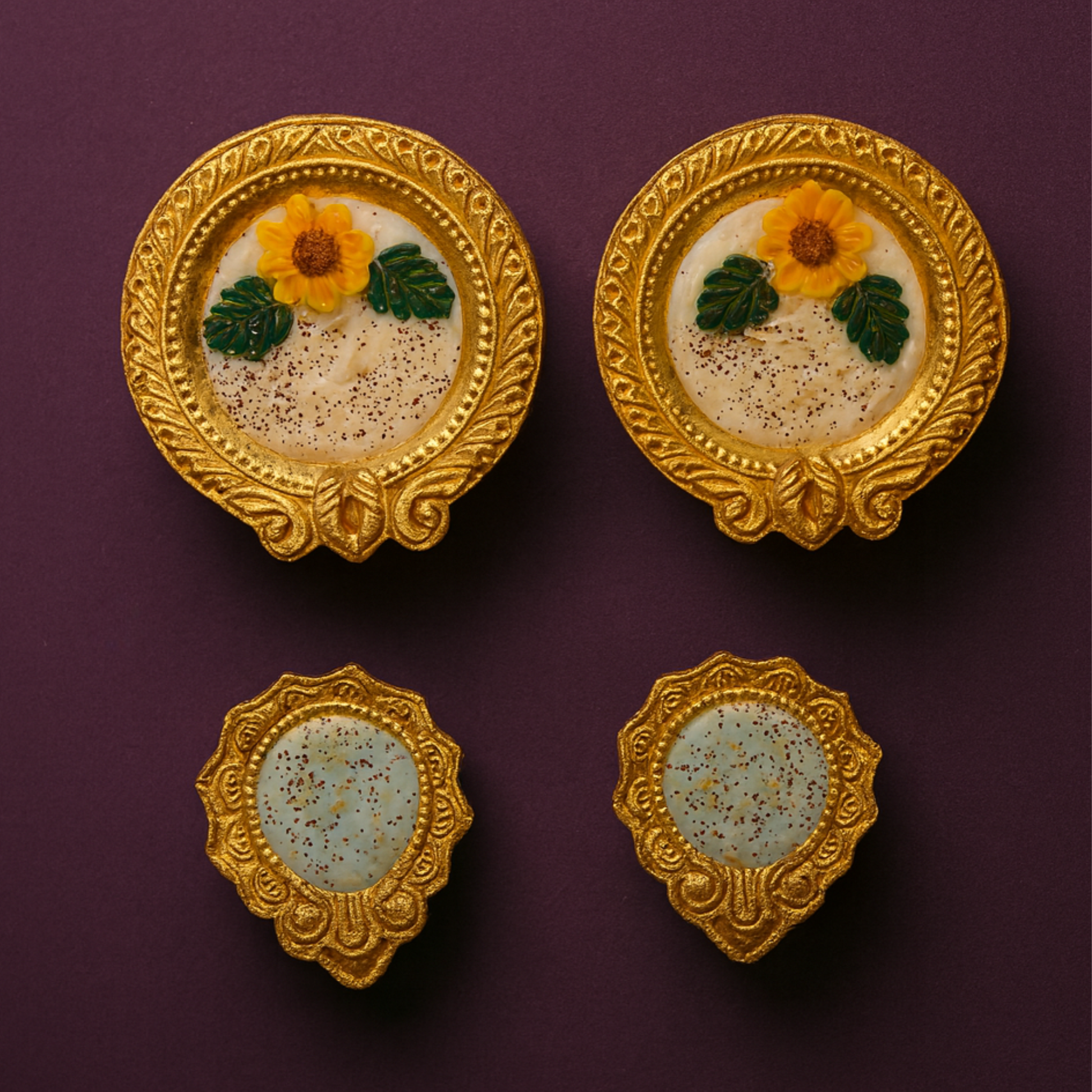 Golden Radiance Diya Fragrant Candle Set by Karigar Kutir — handcrafted soy wax candles in ornate golden holders with floral marigold designs, displayed on a plum background for festive Diwali décor and gifting.