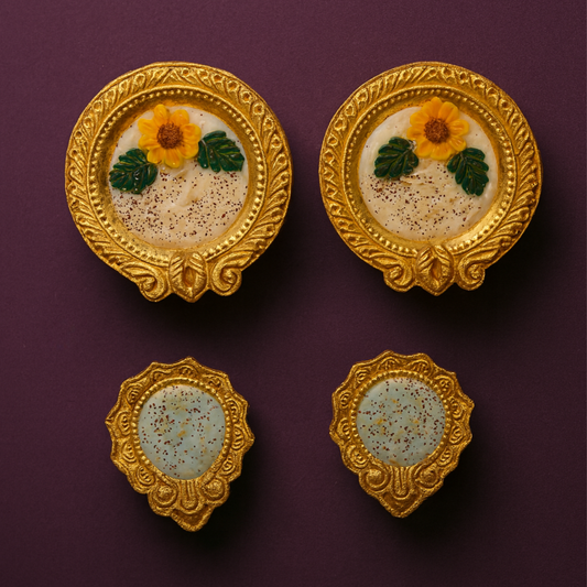 Golden Radiance Diya Fragrant Candle Set by Karigar Kutir — handcrafted soy wax candles in ornate golden holders with floral marigold designs, displayed on a plum background for festive Diwali décor and gifting.