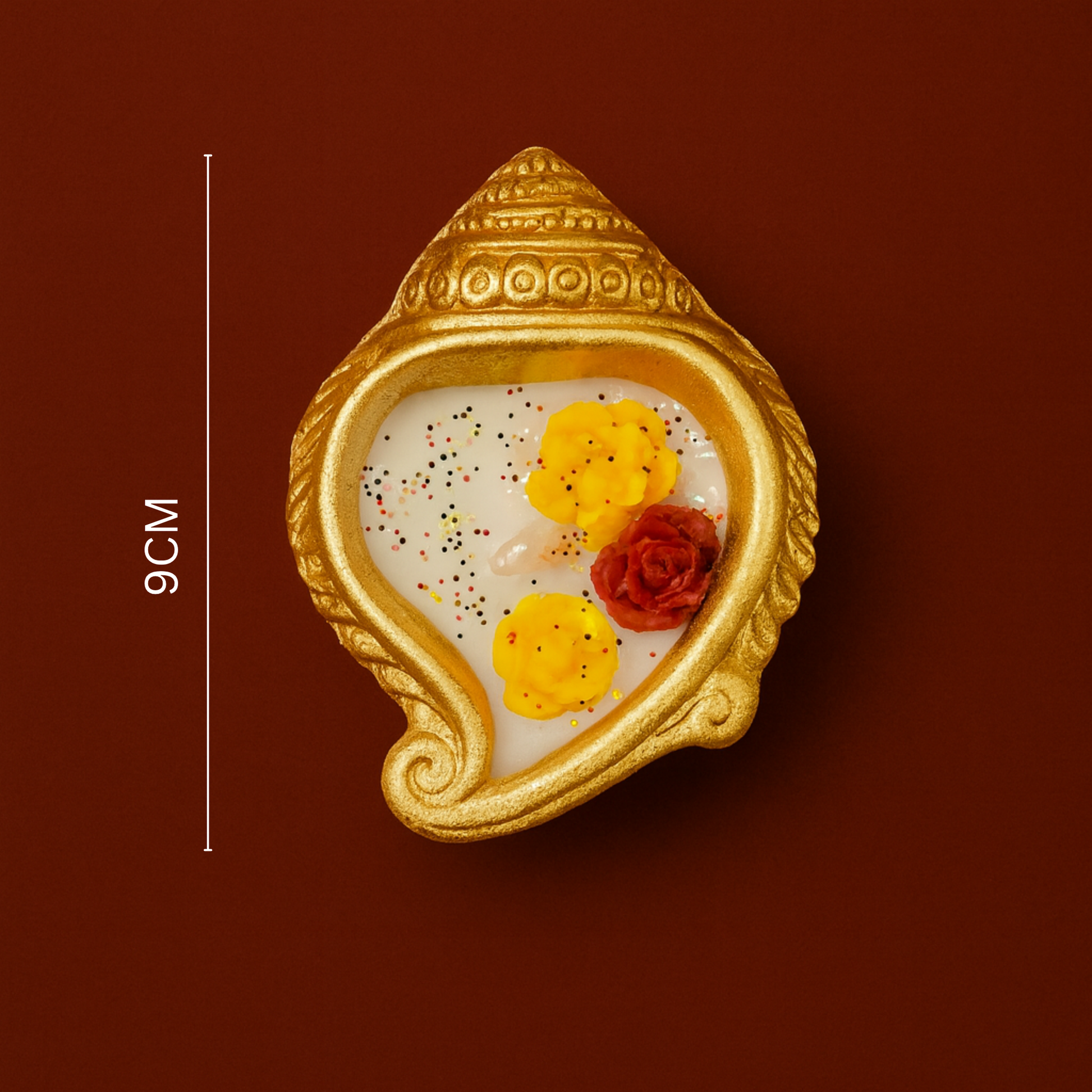 Decorative item with gold shell design and colorful elements on a brown background