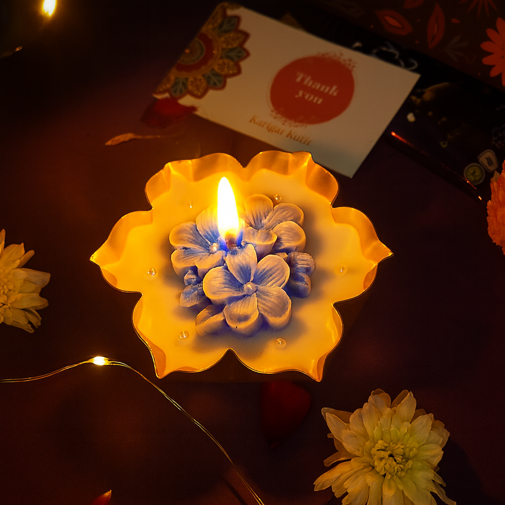 “Neel Pushp Urli Candle Gift Set — handcrafted blue floral candles in festive maroon-and-gold Karigar Kutir box with thank-you card and fairy light setup for Diwali gifting.”